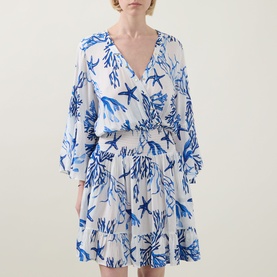Model wearing Naia Beach Celia La Mer Print Kaftan in blue and white marine print, V-neckline, shirred waist, flared mini skirt, three-quarter sleeves