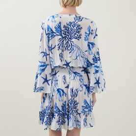 Model wearing Naia Beach Celia La Mer Print Kaftan in white and blue coral and starfish print, back view, shirred waist, flared skirt and sleeves.