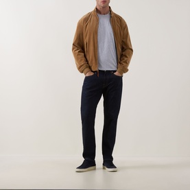 Model wearing Rodd & Gunn The Gunn 2.0 T-Shirt in Light Grey, styled with a tan bomber jacket, navy trousers, and cream trainers.