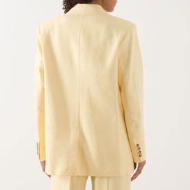 Model wearing Selected Femme blazer in Italian Straw, rear view showing relaxed fit, single back vent, and gold-tone buttons at cuffs.