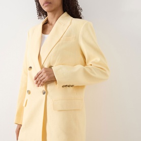 Model wearing Selected Femme Italian Straw blazer in linen-viscose blend, double-breasted with gold buttons and flap pockets.