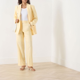 Model wearing Selected Femme Italian Straw linen-viscose blazer and matching wide-leg trousers, styled with a white top and strappy sandals.