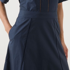 Model wearing Selected Femme Dark Sapphire cotton skirt with front seam detail and side pocket, styled with matching navy top.