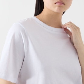 Model wearing Selected Femme Assia Solid T-Shirt in Bright White, with round neckline and dropped shoulders, cropped view.