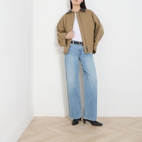 Model wearing Selected Femme Assia Solid T-Shirt in Bright White with tan bomber jacket, light wash wide-leg jeans and black heeled mules.