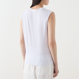 Model wearing Selected Femme Berta Stitched Tank Top in Bright White, sleeveless with straight hem, styled with cream wide-leg trousers. Rear view.