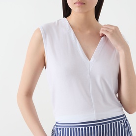 Model wearing Selected Femme Berta Stitched Tank Top in Bright White, V-neckline, sleeveless, styled with blue striped trousers.