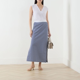 Model wearing Selected Femme Berta Stitched Tank Top in Bright White with blue stripe midi skirt, styled with gold sandals and neutral shoulder bag.