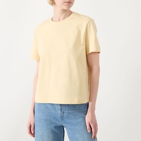 Model wearing Selected Femme Essential Solid T-Shirt in Italian Straw, boxy fit with round neck and short sleeves, styled with light blue jeans.