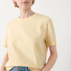 Model wearing Selected Femme Essential Solid T-Shirt in Italian Straw, boxy fit with round neckline and short sleeves, styled with blue jeans