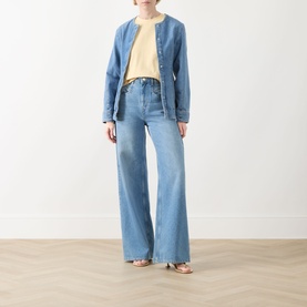 Model wearing Selected Femme Essential Solid T-Shirt in Italian Straw, styled with blue denim jacket and wide-leg jeans, flat sandals.