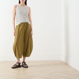 Model wearing Selected Femme Moon Striped Knitted Vest in Birch/Black Stripes, styled with olive barrel-leg trousers and black sandals.