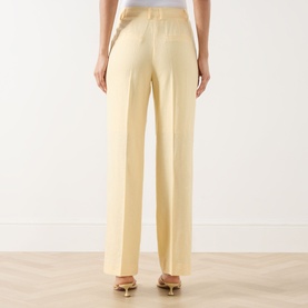 Model wearing Selected Femme Italian Straw wide-leg trousers in linen-viscose blend, rear view, styled with gold heeled sandals.