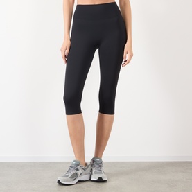 Model wearing Adanola black cropped leggings with high waist, styled with grey trainers
