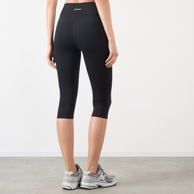 Model wearing Adanola black cropped leggings, high-waisted with slim fit, styled with grey trainers, rear view