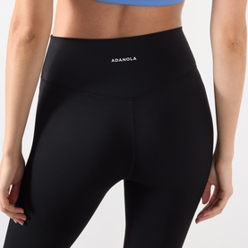Model wearing Adanola black high-waist leggings in nylon-elastane blend, styled with a blue sports bra.