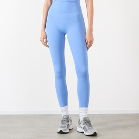 Model wearing Adanola Blossom Blue high-waist leggings, styled with white and grey chunky trainers.