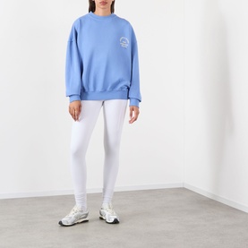 Model wearing Adanola Blossom Blue cotton sweat top, styled with white leggings and trainers