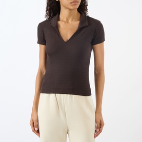 Model wearing Adanola Coffee Bean ribbed cotton polo top with open collar, styled with cream wide-leg trousers.