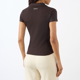 Model wearing Adanola Coffee Bean fitted cotton polo top, back view, styled with cream trousers
