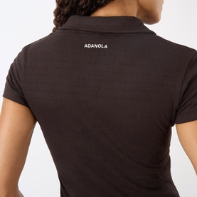 Model wearing Adanola top in Coffee Bean, back view showing ribbed fabric, polo collar and branded logo at nape