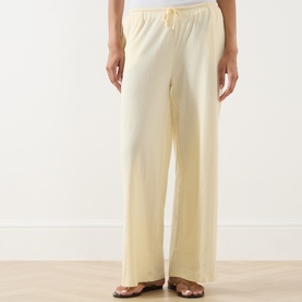 Model wearing Adanola ButterCream wide-leg cotton trousers with elasticated drawstring waist, styled with brown sandals.