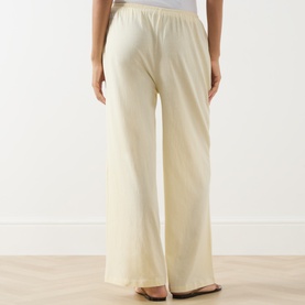 Model wearing Adanola ButterCream wide-leg cotton trousers, rear view showing elasticated waistband and relaxed fit