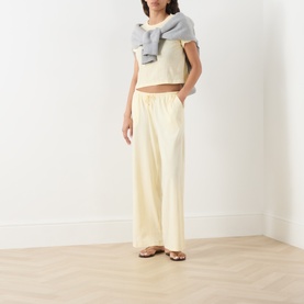 Model wearing Adanola ButterCream wide-leg cotton trousers with elasticated waist, styled with a grey top and brown sandals.