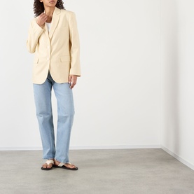 Model wearing Anine Bing Quinn Single-Breasted Blazer in butter yellow with notched lapels, styled with light blue jeans and tan sandals.