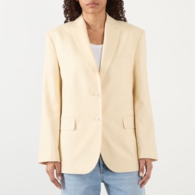 Model wearing Anine Bing Quinn Single-Breasted Blazer in butter yellow with notched lapels and flap pockets, styled with blue jeans