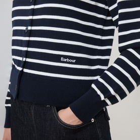 Model wearing Barbour Baiton Striped Cardigan in Dark Navy Stripe, showing ribbed cuffs, button fastening and logo detail, styled with dark jeans.