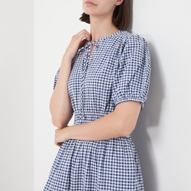 Model wearing Barbour Ashwell Gingham Tiered Dress in Multi Gingham, featuring short puff sleeves, notched neckline with self-tie detail and shirred