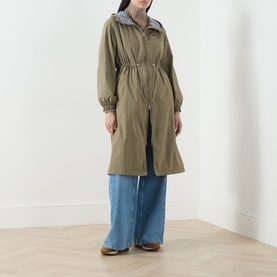 Model wearing khaki hooded drawstring-waist longline parka, styled with wide-leg blue jeans and brown shoes
