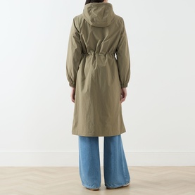 Model wearing khaki hooded drawstring-waist longline rain coat, styled with wide-leg blue jeans, back view