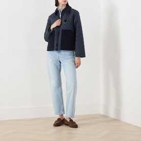 Model wearing Barbour Aylesby Quilted Jacket in Dark Navy with corduroy collar and patch pockets, styled with light-wash jeans and brown loafers