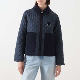 Model wearing Barbour Aylesby Quilted Jacket in Dark Navy with corduroy collar, D-ring detail, and patch pockets, styled with light blue jeans