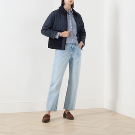 Model wearing Barbour Aylesby Quilted Jacket in Dark Navy with corduroy collar, styled with light-wash wide-leg jeans and brown loafers.