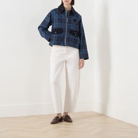 Model wearing Barbour Baiton Check Print Jacket in Weathered Marine plaid with corduroy collar, styled with white trousers and brown loafers.