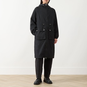 Model wearing Barbour International black polyamide longline jacket with hood, drawstring waist and front pockets, styled with dark trousers and