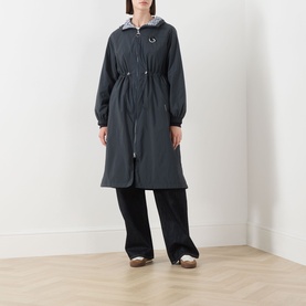 Model wearing Barbour Gracefield Showerproof Jacket in Dark Navy, long parka silhouette with hood, styled with wide-leg black trousers and mule shoes.