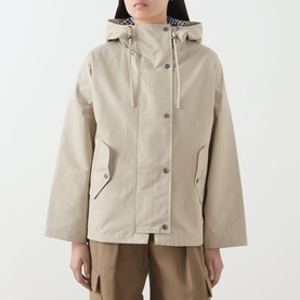 Model wearing Barbour Kingswood Showerproof Jacket in Light Sand, with navy gingham hood lining, snap button placket and angled flap pockets.