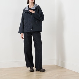 Model wearing Barbour Kingswood Showerproof Jacket in Dark Navy with gingham lining detail, styled with dark wide-leg jeans and black boots