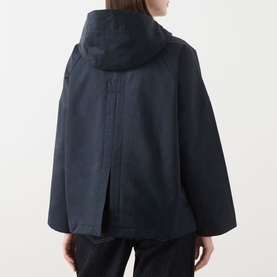 Model wearing Barbour Kingswood Showerproof Jacket in Dark Navy, rear view showing back pleat detail, hood, and wide sleeves.