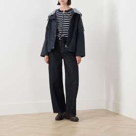 Model wearing Barbour Kingswood Showerproof Jacket in Dark Navy/Gingham with striped top, dark wide-leg jeans and black loafers.