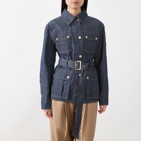 Model wearing Barbour International International Denim Trench Jacket in dark blue with gold-tone hardware and matching belt, styled with tan trousers
