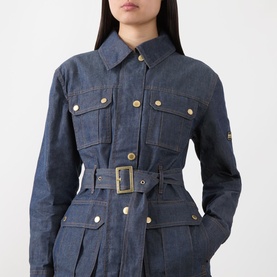 Model wearing Barbour International International Denim Trench Jacket in dark blue with gold-tone buttons, belt, and flap pockets