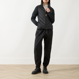 Model wearing Barbour International black quilted jacket with zip front, styled with black joggers and black chunky boots