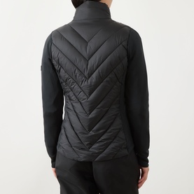 Model wearing Barbour International black quilted jacket, rear view, chevron pattern quilted back panel with stretch side panels
