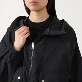 Model wearing Barbour International black polyamide jacket, close-up showing zip fastening, press studs, and stand collar detail