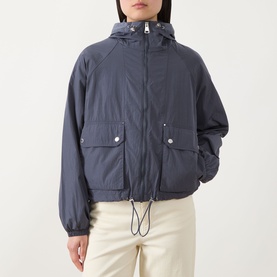 Model wearing Barbour International Maizy Showerproof Jacket in Odyssey navy, with hood, front zip, flap pockets, and drawcord hem, styled with cream